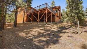 A wooden cabin with a balcony, surrounded by pine trees. - Central Location at this Log Style Cabin! Open Concept Floor Plan! Luxury Cabin! Shuffleboard! BBQ! (Big Bear Lake)