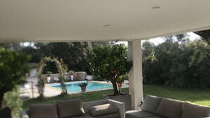 Ein moderner Außenbereich mit Pool, einer Sofagruppe und einem Couchtisch.