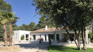 Ein modernes Haus mit Terrasse, Steinmauer und Rasen.