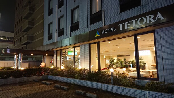 Een hotelgevel 's nachts met een bord waarop 