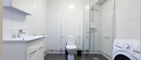 Un baño moderno con inodoro, lavabo y ducha.