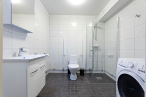 A modern bathroom with a toilet, sink, and shower. - ApartDirect Linköping Vasastaden (Linkoping)