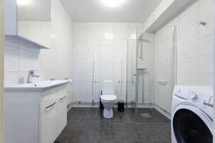 Un baño moderno con inodoro, lavabo y ducha.