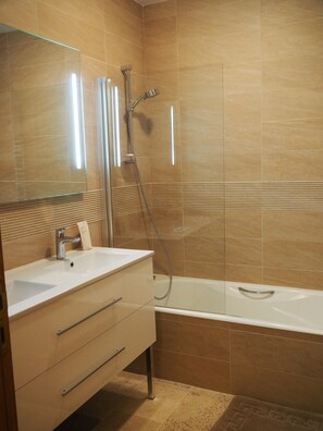 Bañera, secador de pelo, toallas y jabón