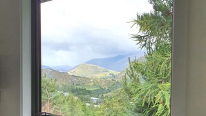 A bathroom with a window overlooking a mountainous landscape. - Entire 2 bedroom detached chalet, in private woodland with valley views. (Arthurs Point)