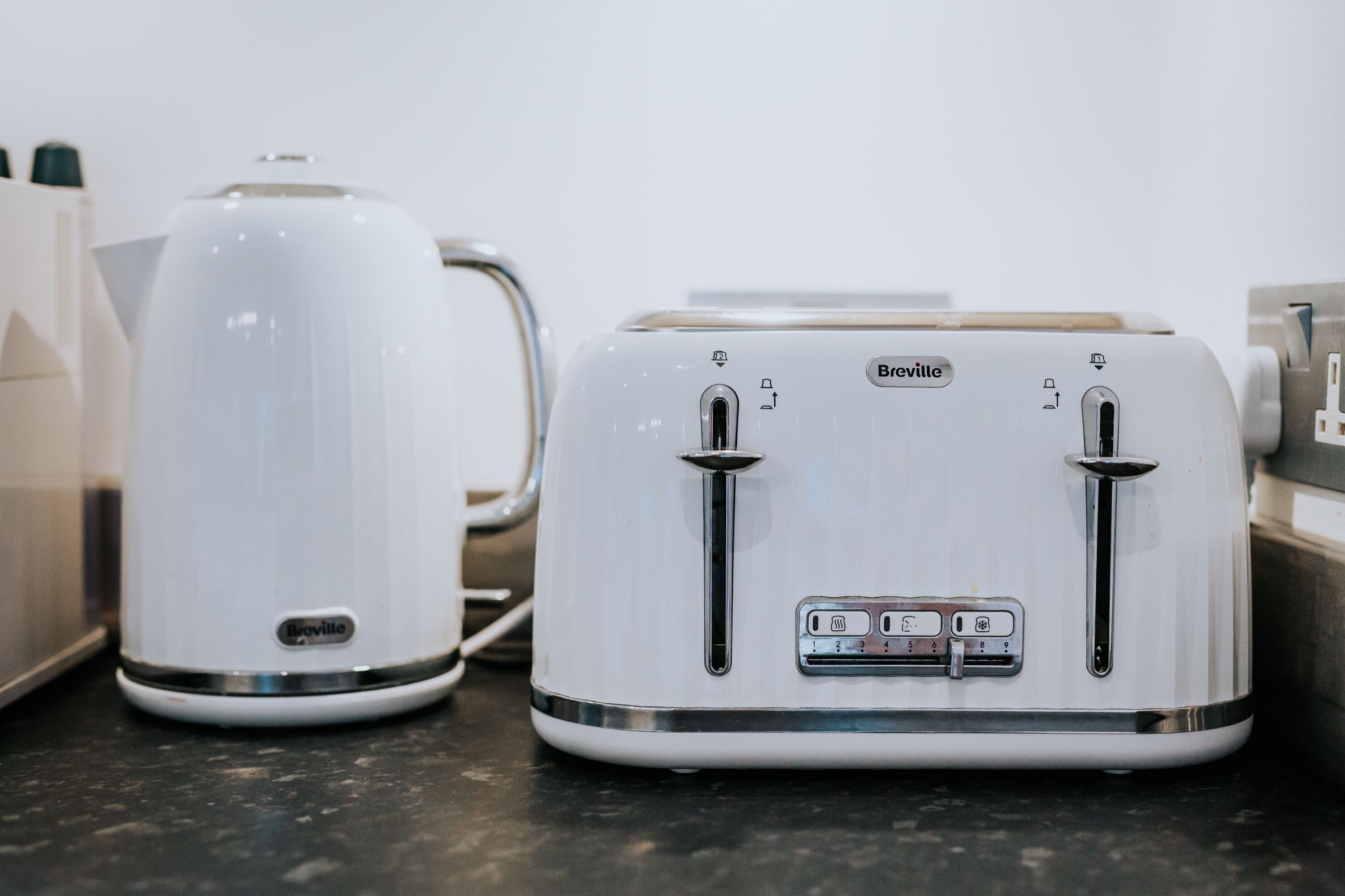 A kitchen with a white coffee maker and a white toaster on a countertop.