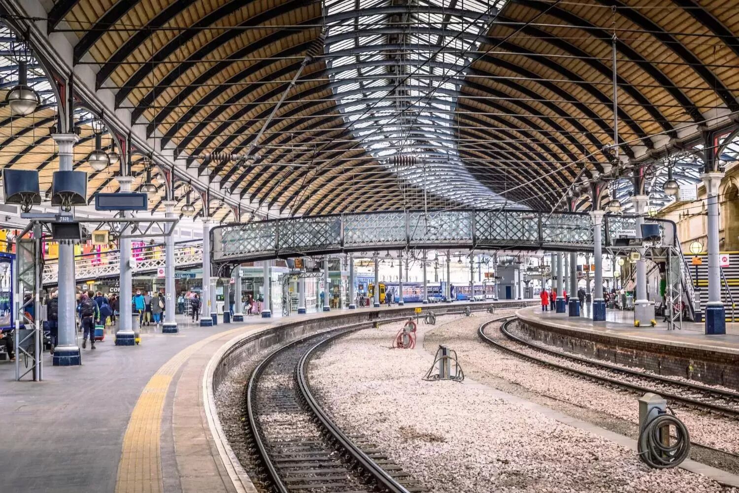 A spacious train station with a high, arched roof and multiple platforms.