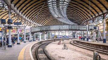 A spacious train station with a high, arched roof and multiple platforms.