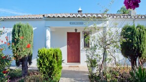 Un bâtiment blanc avec une porte rouge et une enseigne sur laquelle on peut lire « CASA LINDA ».