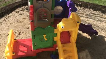 A playground with a climbing structure and a slide.