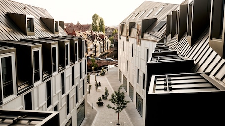 A modern building with a central courtyard, featuring a pedestrian walkway and small trees.