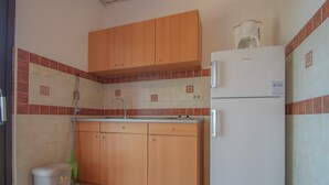 Apartament, terrassa | Cuina bàsica privada | Cafetera i tetera, frigorífic gran i placa de cuina 