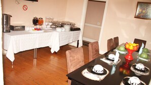 Comedor con mesa de buffet y una mesa dispuesta para una comida.