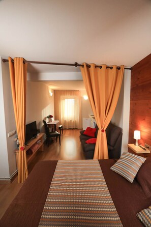 Relax in this stylish room with a large bed, desk, sofa, and dining area.