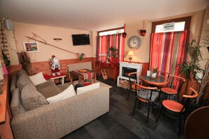 Cozy living room with a comfortable sofa, dining area, and fireplace.