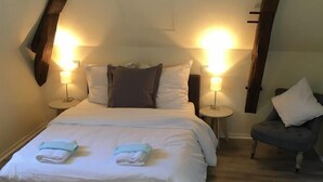 Una camera da letto con un letto, due comodini e una sedia.