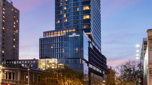 Een hoog, modern gebouw met meerdere verdiepingen en verlichte ramen, waarschijnlijk een hotel of kantoor.