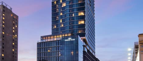 A tall, modern building with multiple floors and illuminated windows, likely a hotel or office building.