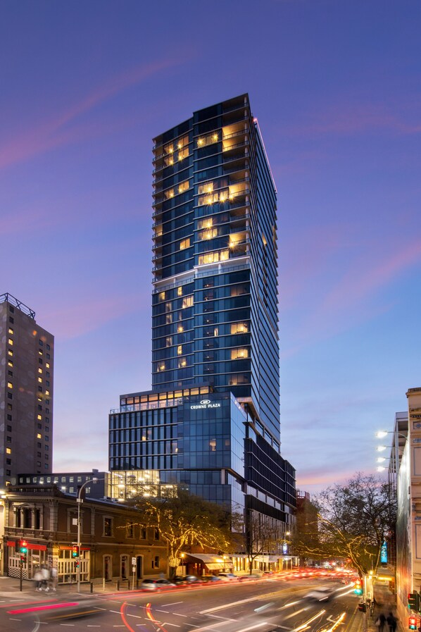 Un grand immeuble moderne, doté de plusieurs étages et de fenêtres illuminées, qui pourrait être un hôtel ou un immeuble de bureaux.