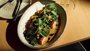 A bowl of food with a fork and knife beside it.