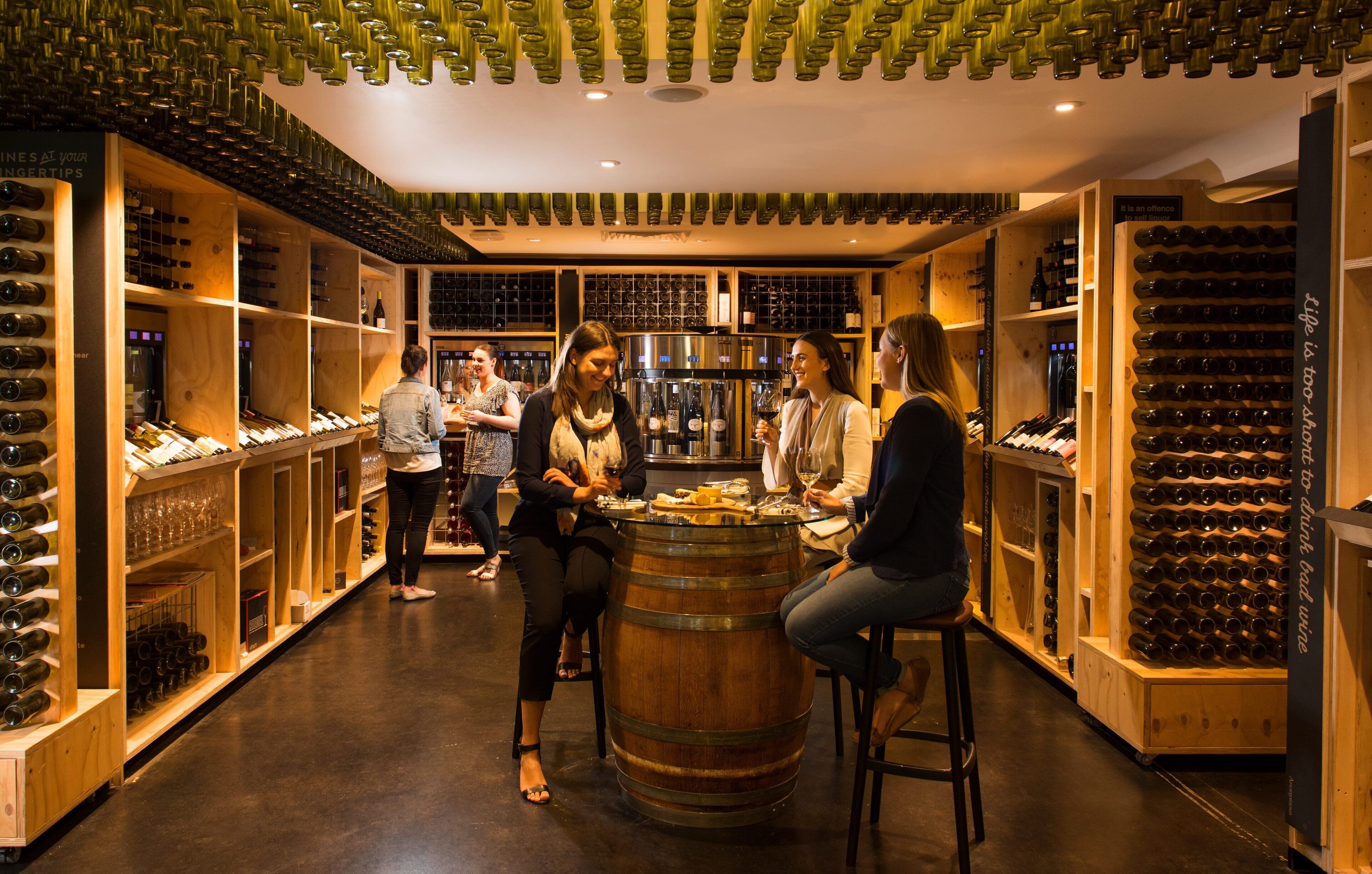 A wine cellar with wooden shelves and racks holding wine bottles.