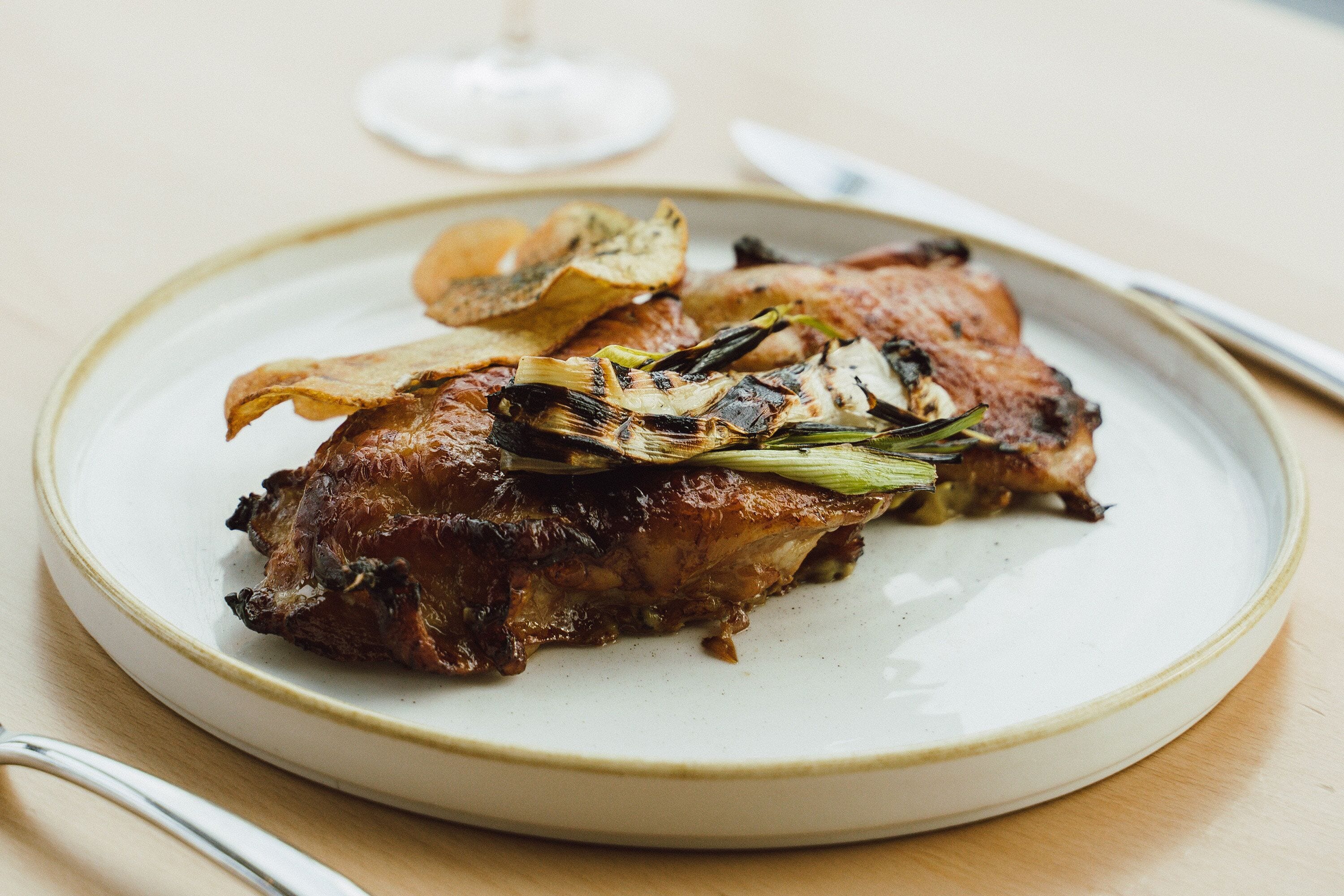 Un plato de pollo asado con verduras sobre un plato de cerámica.