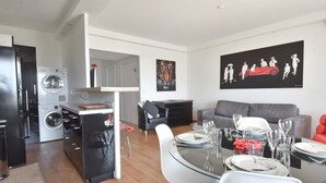 A modern living space with a dining area, kitchen, and laundry room. - 1-Br Apartment, Sea View, Steps from Beaches (Cannes)