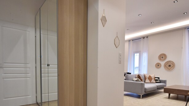 A modern living room with a glass partition, a grey sofa, and a wooden coffee table. - Modern 3-Br Apartment in City Center, 5 Minutes from Palais and Beache (Cannes)