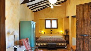 A cozy room with a bed, a rocking chair, a small table, and a cabinet. - Casa del Riu (Beneixama)