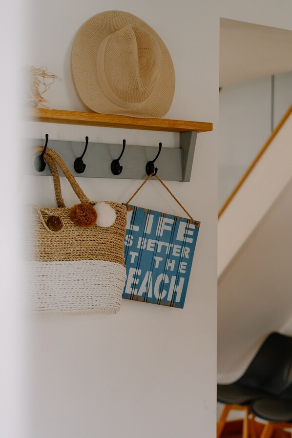 A wall-mounted shelf with a straw hat, a woven bag, and a motivational sign. - The Rock, Sleeps 8, Pets, Hot Tub (Braunton)