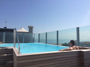 Una piscina al aire libre de temporada, tumbonas