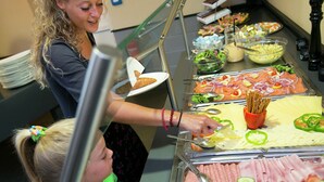 Un buffet proposant une variété de plats, notamment des viandes, des salades et du pain.