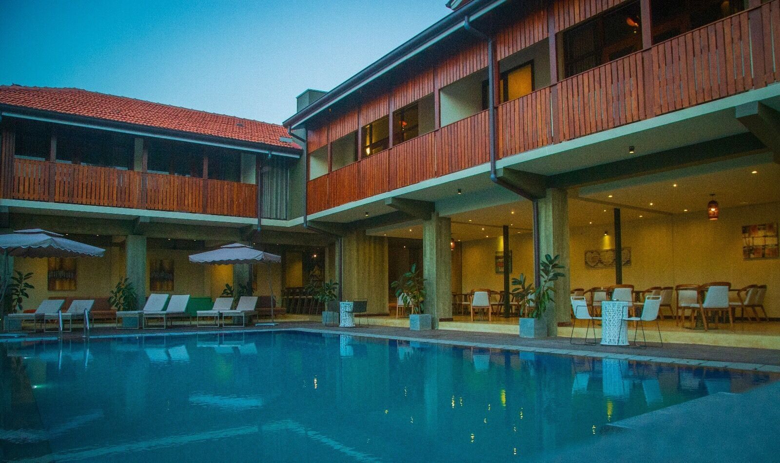 Una piscina al aire libre, sillones reclinables de piscina