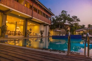Una piscina al aire libre, sillones reclinables de piscina