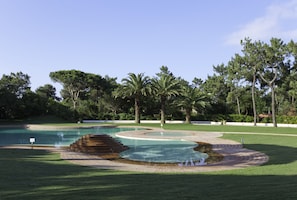 Piscine extérieure en saison, parasols, chaises longues