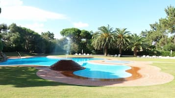 Una piscina al aire libre de temporada, sombrillas, tumbonas