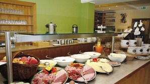 A buffet with various food items including fruits, meats, and eggs.