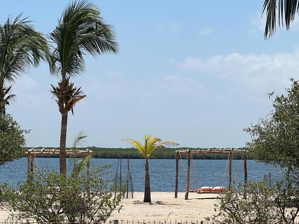 A beach with palm trees, a wooden structure, and a view of the water.