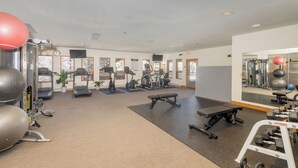Ein Fitnessstudio mit Laufbändern, Übungsbällen und Krafttrainingsgeräten.
