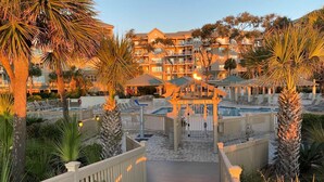 A resort with a pool area, multiple balconies, and palm trees.
