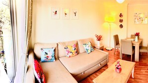 A cozy living room with a sofa, coffee table, and dining area. - Apple Perch 2BR Flat-Free Parking (Oxford)