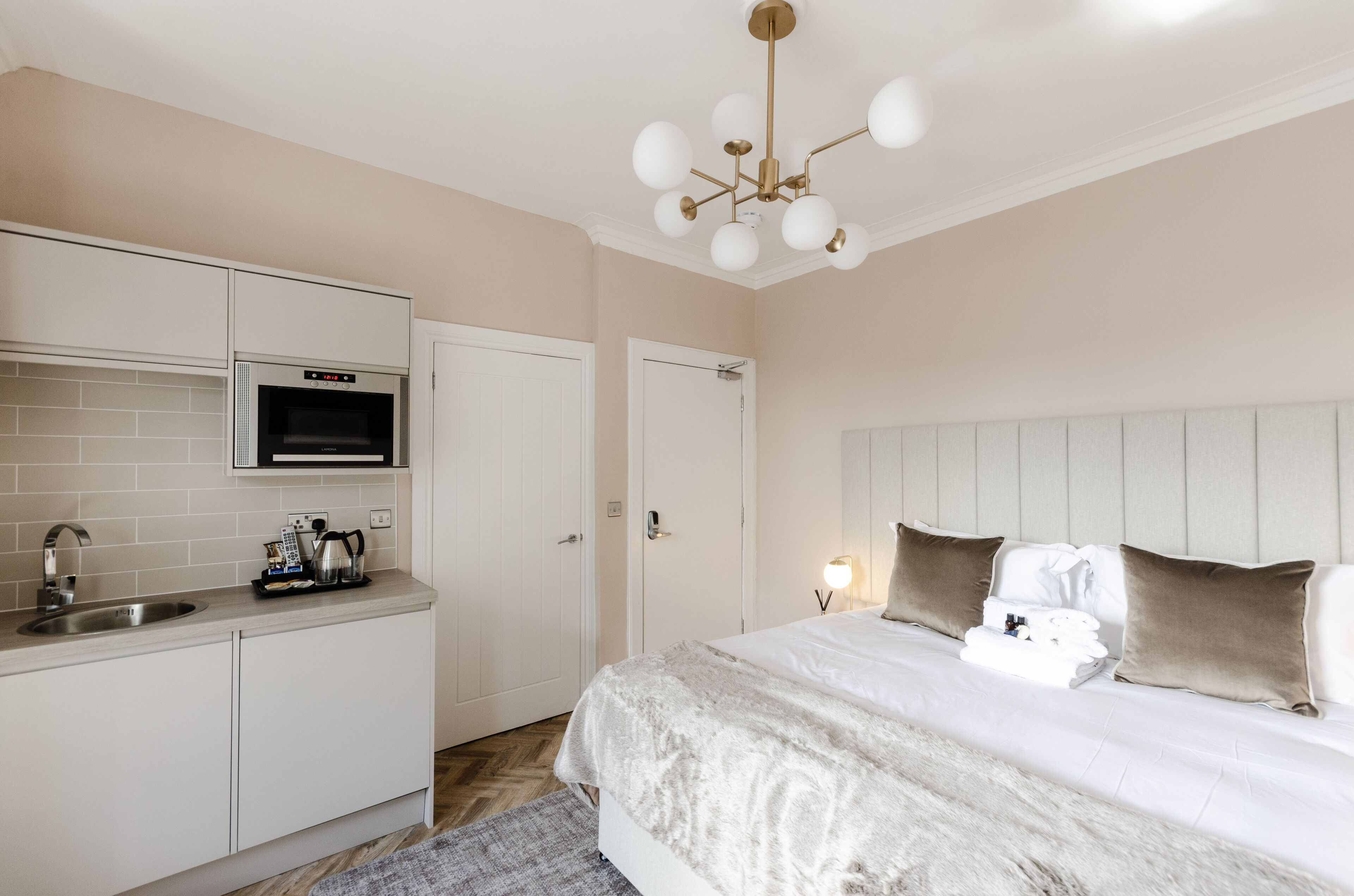 A bedroom with a bed, bedside table, and a built-in oven.