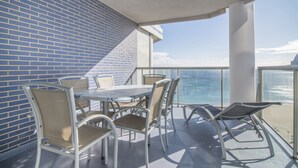 A balcony with a table and chairs, a view of the ocean, and a brick wall. - First line / Wifi / Spa / Seaviews / Heated pool / Pets (Calpe)