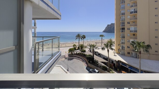 A high-rise building with a balcony overlooking a beach. - First line / Wifi / Spa / Seaviews / Heated pool / Pets (Calpe)