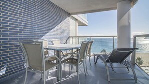 A balcony with a table and chairs, overlooking a beach and ocean. - First line / Wifi / Spa / Seaviews / Heated pool / Pets (Calpe)