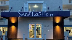 L’entrée d’un hôtel, avec une enseigne indiquant « Sand Castle ».