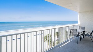 Un balcon avec une balustrade blanche donnant sur une plage.