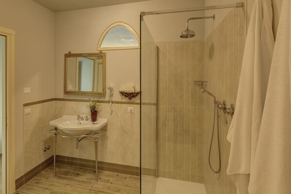 A bathroom with a shower, sink, and mirror.