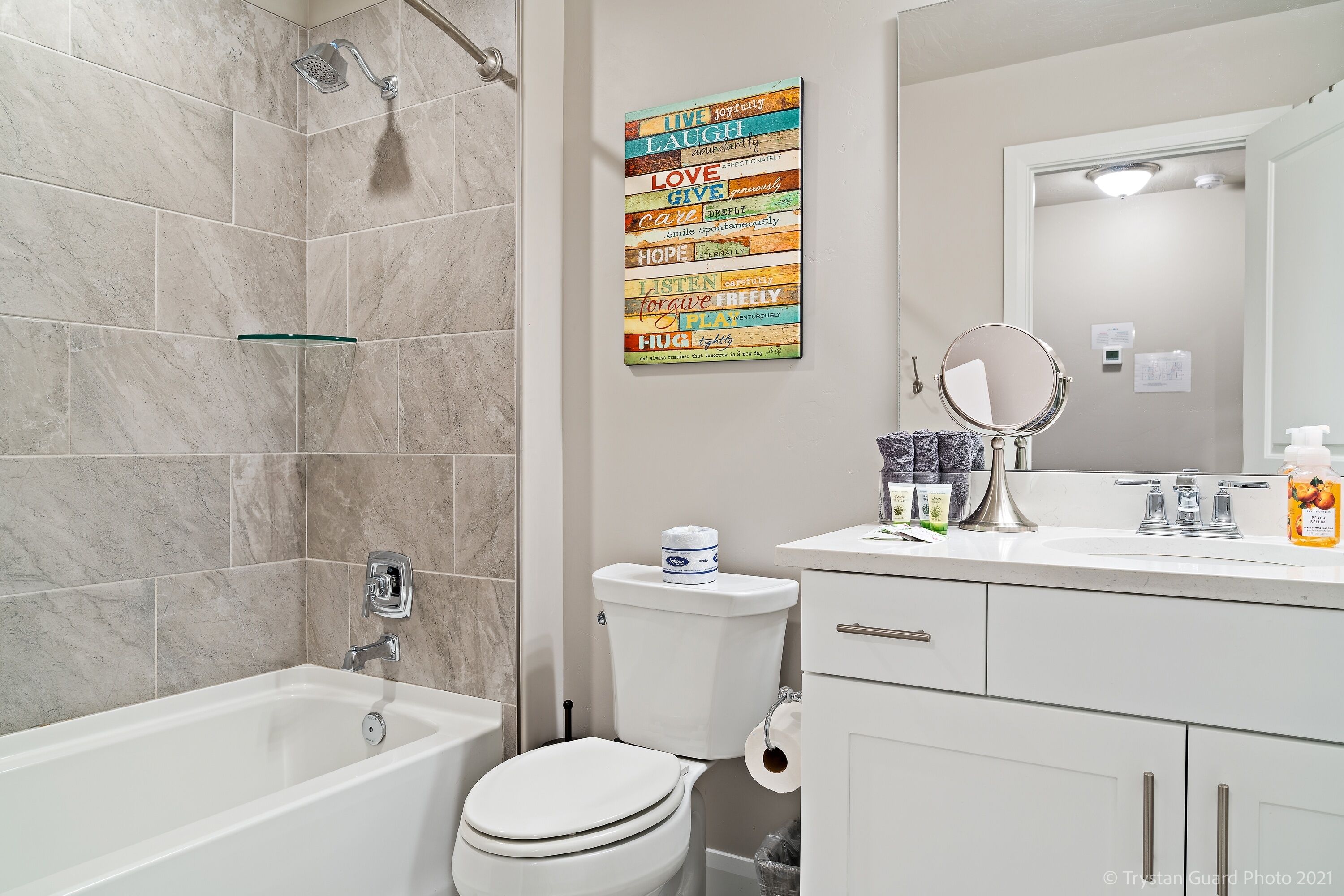 A modern bathroom with a bathtub, toilet, and sink.