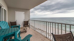 Un balcon avec des chaises et une table donnant sur une plage.